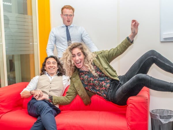 Drie teamleden, vrolijk op de bank